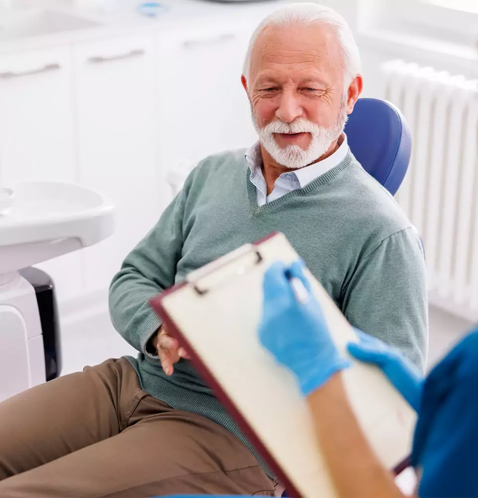 Smiling senior patient in the dental chair during an implant check-up